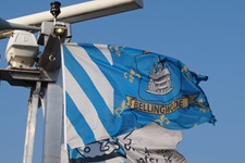 Eine blau-weiße Flagge mit dem Wappen des niederländischen Dorfes Bellingwolde weht im Wind.