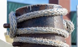 Maritime Impression: ein um einen Anlegepoller gewickeltes Schiffstau.
