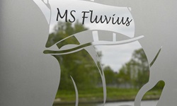 Detailbild eines Fensters der Fluvius mit Fensterbild, das ein Schiff mit der Aufschrift "MS Fluvius" zeigt