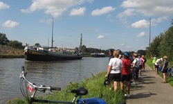 Reiseteilnehmer warten nach dem Ende der täglichen Radtour am Ufer auf die MS Gandalf.