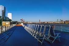 Rücken an Rücken stehende blaue Stühle warten auf dem Sonnendeck der MS Princess auf die Gäste.