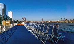 Rücken an Rücken stehende blaue Stühle warten auf dem Sonnendeck der MS Princess auf die Gäste.