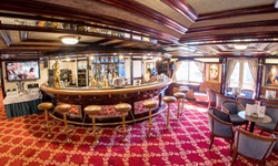 Hocker an der Bar der MS Prinzessin Katharina und die blauen Sessel im Salon warten auf Gäste.