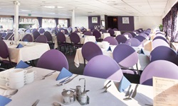 Das gemütlich eingedeckte Restaurant mit blauen Stühlen auf dem Schiff Serena