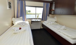 Zwei-Bett-Kabine mit getrennten Betten und einem großen Fenster auf dem Promenandendeck der Serena
