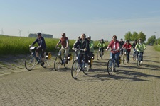 Eine radlergruppe fährt auf einer breiten gepflasterten Straße durch Holland