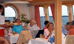 Passagiere der Classic Lady sitzen im Restaurant und bekommen das Essen serviert
