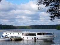 Blick auf die schöne MS Classic Lady, die an einem Holzsteg in Masuren angelegt hat - auf dem Steg sind die Räder abgestellt