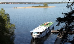 Blick auf die MS Classic Lady, die an einem Holzsteg in Masuren angelegt hat
