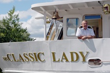 Kapitän der Classic Lady schaut von der Brücke herab