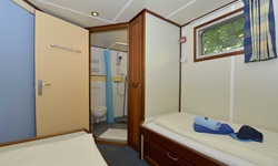 Eine Zwei-Bett Kabine mit zwei getrennten Betten mit Blick zum Bad der MS Mecklenburg