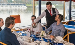 Ein aufmerksamer Kellner schenkt im Restaurant der MS Primadonna Rotwein aus.