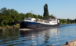 Die MS Sarah in voller Fahrt auf einem Fluss.