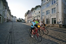 Drei Radler fahren durch eine Zone für Fußgänger und Radfahrer