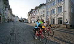 Drei Radler fahren durch eine Zone für Fußgänger und Radfahrer