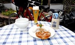 Bayrisches Frühstück auf einem Tisch gedeckt: Weißwurst mit Brezel, süßem Senf und einem Weißbier
