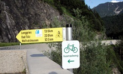 Ein Wegweiser des Isarradwegs an einer Kreuzung in Richtung Bad Tölz