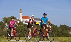 Drei Radler fahren einen Radweg auf der Strecke der Münchner Seenrunde entlang