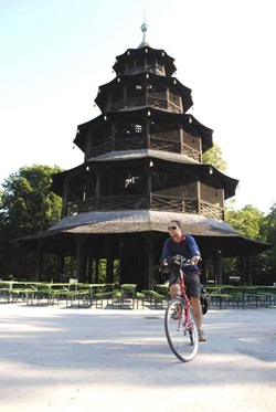 Ein Radfahrer fährt im Englischen Garten von München am Chinesischen Turm vorbei
