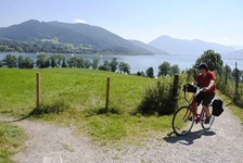 Ein Radfahrer fährt von einem See einen schmalen Weg hinauf