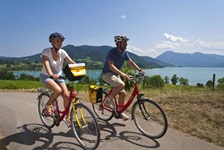 Radfahrer auf einem Radweg - hinter ihnen der Starnberger See auf der Strecke der Münchner Seen bzw. der bayerischen Seenrunde