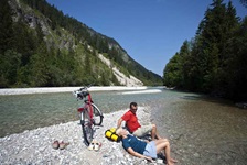 Zwei Radler machen Pause auf einem Flussbett auf der Strecke der Münchner Seenrunde