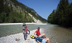 Zwei Radler machen Pause auf einem Flussbett auf der Strecke der Münchner Seenrunde
