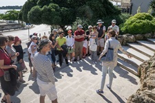 Eine Gruppe Touristen nimmt an einer Stadtbesichtung in Sibenik teil - eine Frau erklärt und zeigt auf die Mauern einer Treppe