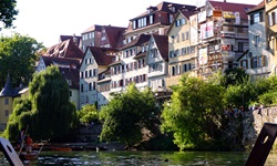 Blick auf die Häuserpromenade am Neckar in Tübingen - auf dem Neckar sind Stocherkanus zu sehen