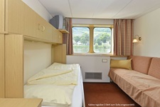 Eine Zweibett-Kabine auf der MS Normandie bei Tag (mit zum Sofa umgewandeltem zweitem Bett).