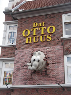 Ein Ottifant durchbricht die Fassade des Otto-Huuses in Emden.