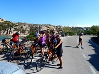 Eine Radlergruppe macht am Straßenrand Pause und genießt den Ausblick auf die faszinierenden Felsformationen der Gallura.