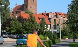 Ein Radfahrer fährt auf einem Radweg zu einer Stadt an der Mecklenburgischen Seenplatte