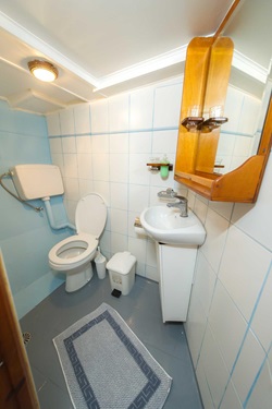 Einblick in das Badezimmer mit Waschbecken und WC auf dem Motorsegler Panagiota