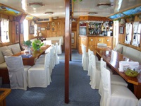 Der Salon der Panagiota mit Blick auf die Bar und Bänken und Stühlen, die mit weißen Hussen überzogen sind