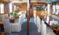 Der Salon der Panagiota mit Blick auf die Bar und Bänken und Stühlen, die mit weißen Hussen überzogen sind