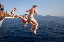 Passagiere der Panagiota springen mit ihren Badesachen vom Schiff ins Meer