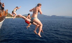 Passagiere der Panagiota springen mit ihren Badesachen vom Schiff ins Meer