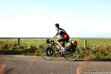 Ein Radfahrer fährt an einer flachen Weide mit Blick zum Meer in Dänemark vorbei