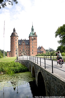 Radfahrer überqueren eine Brücke in Dänemark und fahren auf ein Tor zu