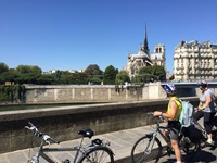 Zwei RadlerInnen bestaunen aus der Ferne die weltberühmte Kathedrale Notre Dame de Paris.