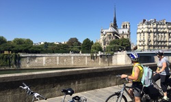 Zwei RadlerInnen bestaunen aus der Ferne die weltberühmte Kathedrale Notre Dame de Paris.