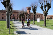 Zwei Radfahrer fahren durch einen Park ein einem Schloss bei Turin