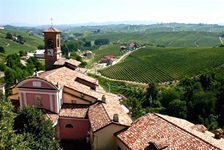 Atemberaubender Panoramablick über die sich bis zum Horizont erstreckenden Weinberge; im Vordergrund die Kirche von Barolo.