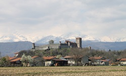 Blick auf das Castello Pavone im Piemont mit den schneepedeckten Alpengipfeln im Hintergrund