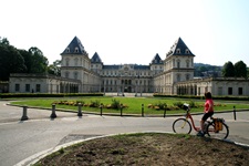 Eine Radlerin bewundert das imposante Schloss Stupinigi in Nichelino.