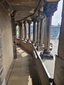 Blick in einen Außengang mit zahlreich verzierten Säulen auf der Porta Nigra
