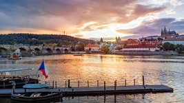 Blick über die vom Sonnenuntergang beleuchtete Moldau nach Prag