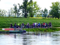 Eine Radlergruppe wartet an einer Fähranlegestelle der Elbe.