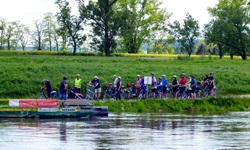 Eine Radlergruppe wartet an einer Fähranlegestelle der Elbe.